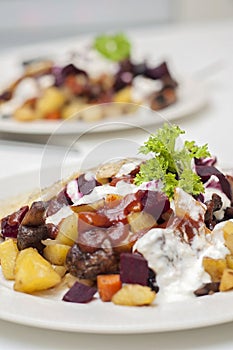 Finnish potato hash with mushroom, beefroot and carrot. Vegetarian diced panfried food with mayonnaise, ketchup and parsley on top