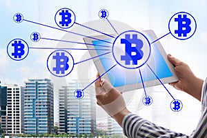 Fintech concept. Scheme with bitcoin symbols and man using tablet on background