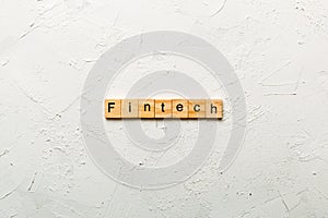 FINTECH word written on wood block. FINTECH text on cement table for your desing, concept