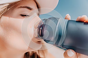 Fintess woman drinking water. Happy, active middle aged woman standing on beach and drinking water after excersise