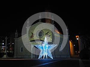 Fiorano al Serio, Bergamo, Italy. The main church of Saint Giorgio with a big illuminated Christmas star during the Christmas time photo