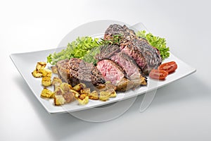 Fiorentina T-bone steak cut on rectangular white plate photo