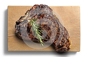 Fiorentina T-bone steak cut on rectangular wooden chopping board photo
