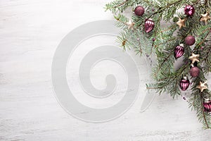 Fir branch with Christmas decoration on white shabby wooden board with copy space for text.