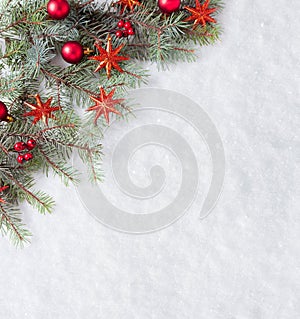 Fir branch with Christmas decorations on the background of natural snow