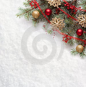 Fir branch with Christmas decorations on the background of natural snow