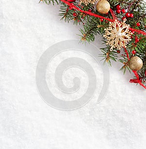 Fir branch with Christmas decorations on the background of natural snow