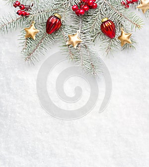 Fir branch with Christmas decorations on the background of natural snow with empty space for text. Flat lay