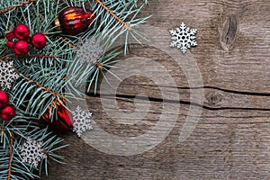 Fir branch with with Christmas decorations on old wooden background with copy space for text. Selective focus