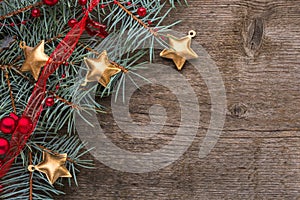 Fir branch with Christmas decorations on old wooden background with empty space for text. Top view