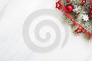 Fir branch with Christmas decorations on old wooden shabby background with empty space for text