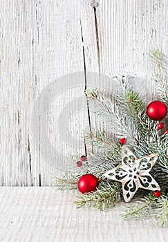 Fir branch with Christmas decorations on white rustic wooden background with copy space for text