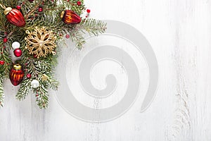 Fir branch with Christmas decorations on white shabby wooden board with copy space for text. Flat lay.  Christmas and New Year hol