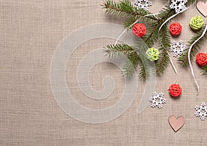 Fir branch, snowflakes, balls and hearts on beige