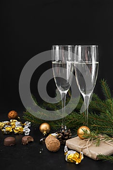 Fir branches, 2 glasses of champagne, chocolates with Golden wrappers, gift box, balls, sparkling wine, Christmas decor