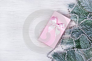 Fir branches and gift on white background. Beautiful pink box copy space. Christmas and New Year concept