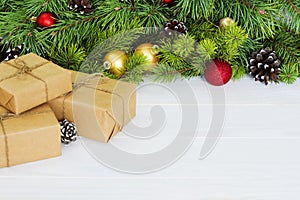 Fir branches with ornaments - gift box, pine cones holly and baubles. Christmas background, copy space