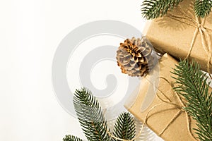 Fir branches with pine cones and gifts in craft paper and scourge on a white background for text for the holiday christmas or new