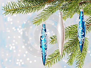 Fir tree branch with blue and white toys, soft bokeh