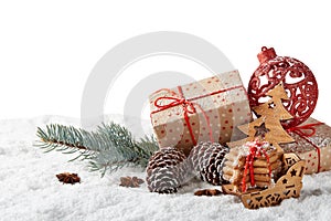 Fir tree branch, decorations, gingerbread cookies and gift boxes on a winter snow background with copy space.