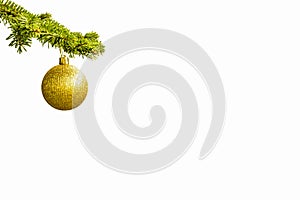Fir tree branch with a golden glitter ball on white background. Bokeh effects. Christmastime. Christmas postcard
