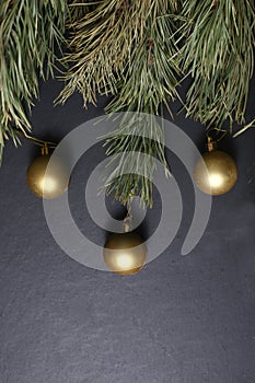 Fir tree branches and christmas balls isolated on dark background flat lay