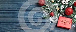 Fir tree branches with Christmas decoration on blue wooden background, flat lay