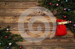 Fir tree branches with Christmas decoration and Santa Claus bag against old vintage style wooden planks. Christmas concept