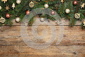 Fir tree branches with Christmas decoration on wooden background. Space for text