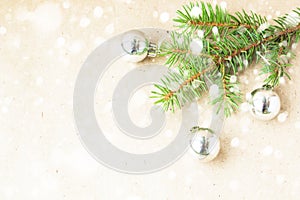 Fir tree branches decorated with silver christmas balls as border on a snow rustic holiday background frame