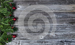 Fir tree branches and red ornaments on wood planks for a merry Christmas or happy New Year holiday celebration concept