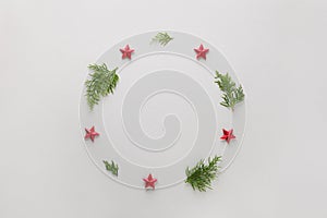 Fir tree branches and red stars shaped as wreath frame on white background, Merry Christmas and Happy Hew composition