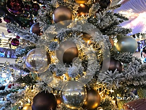 Fir tree decorated with christmas balls. Close-up view of beautiful christmas tree with colorful baubles and illuminated garland.