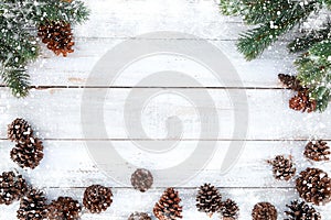 Fir tree and pine cones decorating rustic elements on white wood table with snowflake