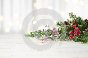 Fir tree twig with frosted red berries on wooden table