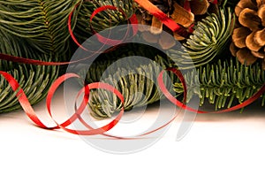Fir-tree twigs with red ribbons and cones