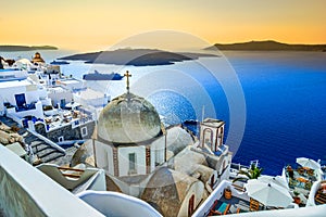 Fira, Santorini, with white village, cobbled paths, greek orthodox blue church and sunset over caldera. Cyclades, Greece