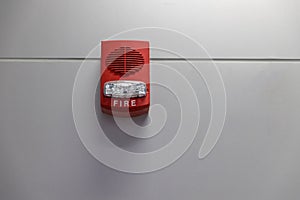 A fire alarm with built in strobe light to alert in case of fire. A sound and strobe fire alarm is mounted to an interior wall as