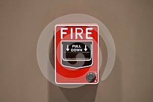 Fire alarm button The red square box style Attached to the wall of the brown room, a warning sign in the event of fire For the saf