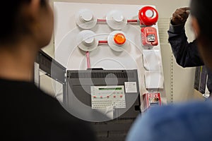 Fire alarm and mock sprinkler system attached to a white wall used for training