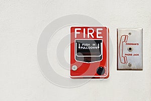Fire Alarm Notifier and Fireman's Phone Jack on White Cement Plaster Wall with Copy Space for Security Concept