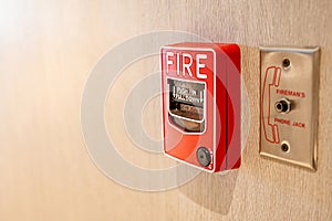 Fire alarm switch and phone jack on wooden wall