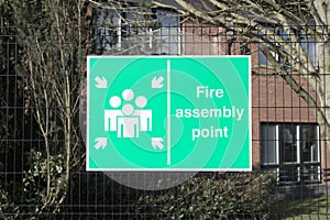 Fire assembly point sign at office workplace factory for safety security of workers people employees