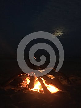 Fire on Beach during Full Moon Rising on Kauai Island, Hawaii.