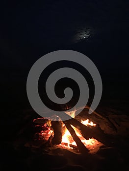 Fire on Beach during Full Moon Rising on Kauai Island, Hawaii.