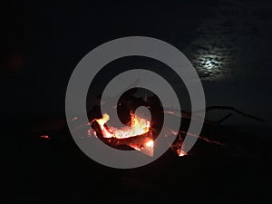Fire on Beach during Full Moon Rising on Kauai Island, Hawaii.