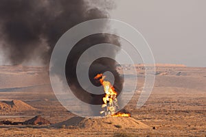 Fire and black smoke of burning oil during a fire power demonstartion of the Israeli Defence Forces in the Negev Desert photo