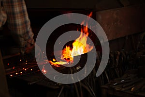 Fire of blacksmith in the blacksmith`s workshop. Blacksmith at work.