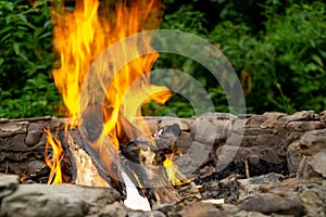 Fire burning in the fireplace in the nature or in the grill.