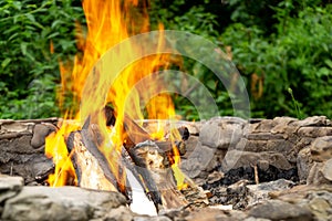 Fire burning in the fireplace in the nature or in the grill.